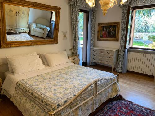 a bedroom with a bed and a mirror on the wall at Villa Graziella Perugia in Perugia