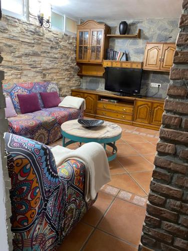 a living room with a couch and a tv at Bodega íntima in Zaragoza
