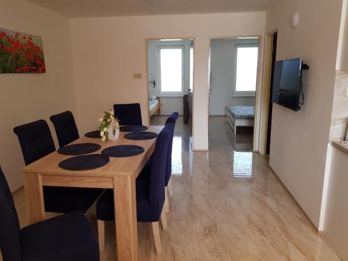 a dining room with a table and blue chairs at Apartmán s vinným sklepem VIKTORIE Pouzdřany in Pouzdřany