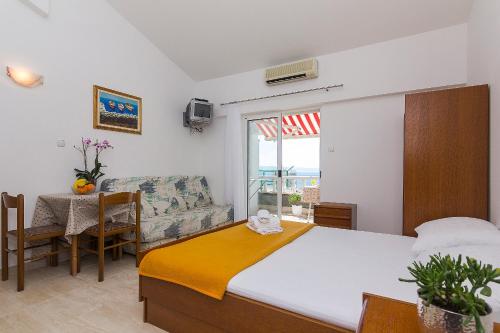 a bedroom with a bed and a couch and a table at Apartments Erceg in Makarska