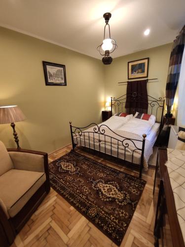 a bedroom with a bed and a chair and a couch at Dom pod Zegarem in Przemyśl