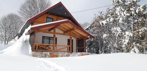 a log cabin in the snow in the woods at Eco Village Highlander in Žabljak