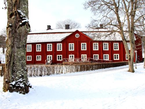 a red barn with snow on the ground in front at Gripsholms BnB in Mariefred