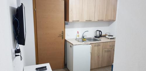 a small kitchen with a sink and a refrigerator at Apartman za dvoje in Travnik