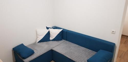 a blue bench with two pillows in a room at Apartman za dvoje in Travnik
