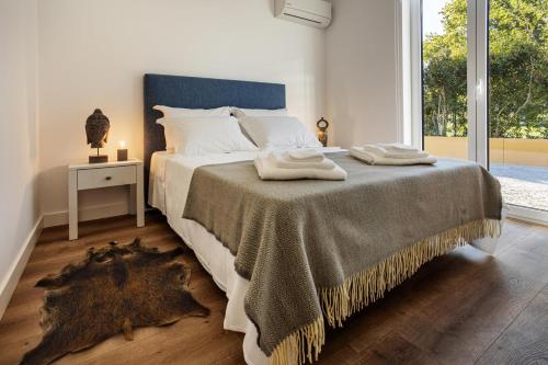 a bedroom with a bed with a blanket and a window at QSF Agro Turismo Quinta da Sagrada Família in Évora