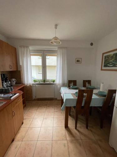 a kitchen with a table and chairs and a window at Willa Mira 200 metrów od morza in Międzyzdroje