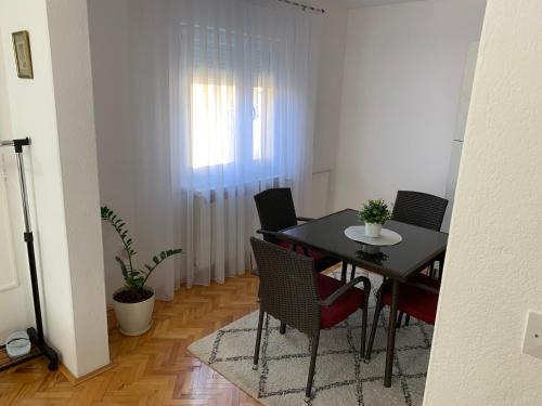 a dining room with a black table and chairs at Apartmani Nedim in Dubrave Gornje