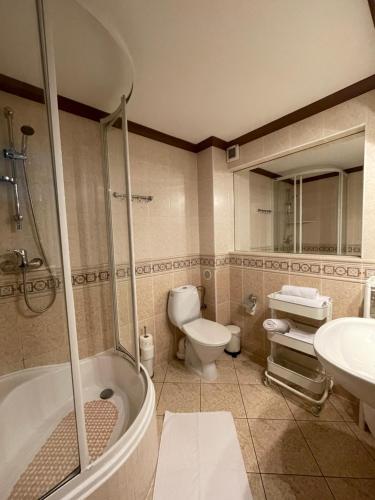 a bathroom with a tub and a toilet and a sink at Willa Mira 200 metrów od morza in Międzyzdroje