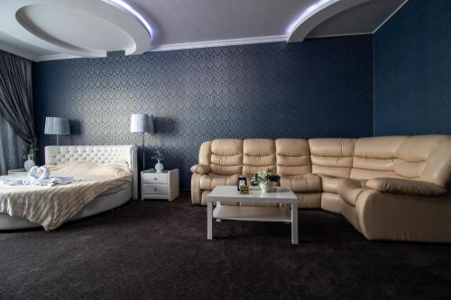 1 dormitorio con cama, sofá y mesa en Hotel Oblaka, en Mineralnye Vody