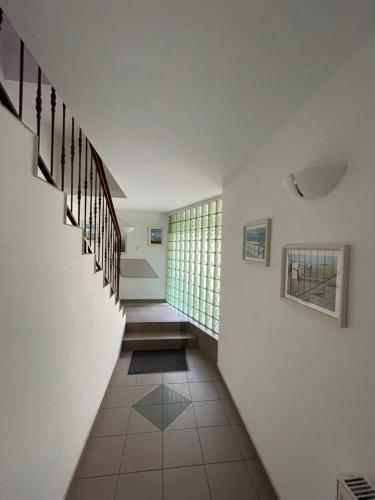 a hallway of a house with stairs and a window at Willa Mira 200 metrów od morza in Międzyzdroje