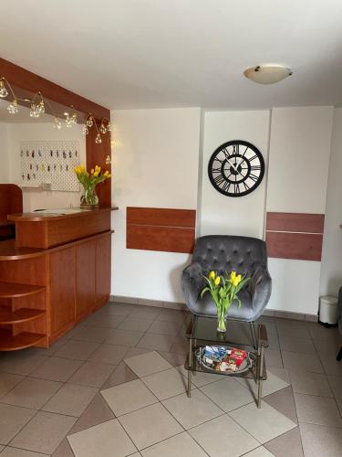 a waiting room with a chair and a clock on the wall at Willa Mira 200 metrów od morza in Międzyzdroje