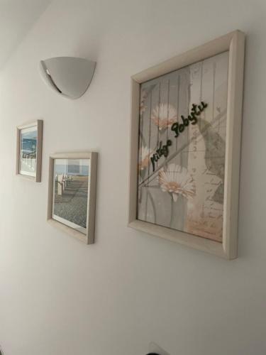 two framed pictures on a wall with a vase of flowers at Willa Mira 200 metrów od morza in Międzyzdroje