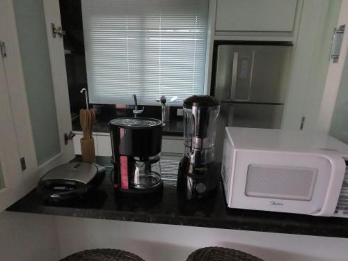 um balcão de cozinha com comodidades para preparar café e um micro-ondas em Casa de campo em resort com banheiras água termal em Santo Amaro da Imperatriz