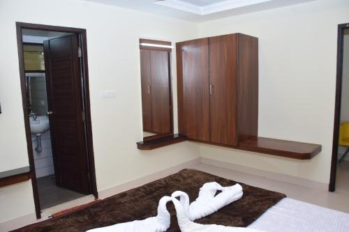 a bathroom with a bed and a sink and a mirror at B2B Home Stay in Kodaikānāl