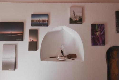 a wall with a vase and pictures on it at Atelier Boutique Hotel in Shkodër