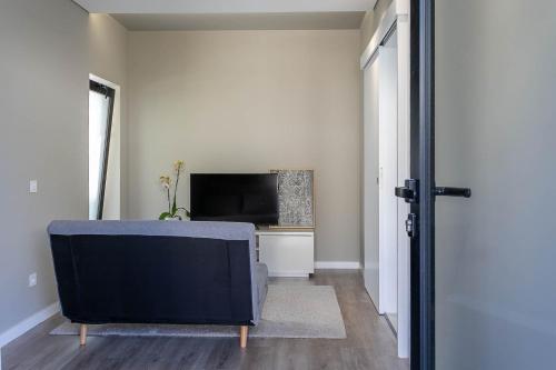 a living room with a couch and a television at Pateo 780 in Vila Nova de Gaia
