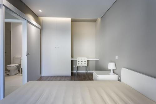 Habitación blanca con cama y escritorio en Pateo 780, en Vila Nova de Gaia