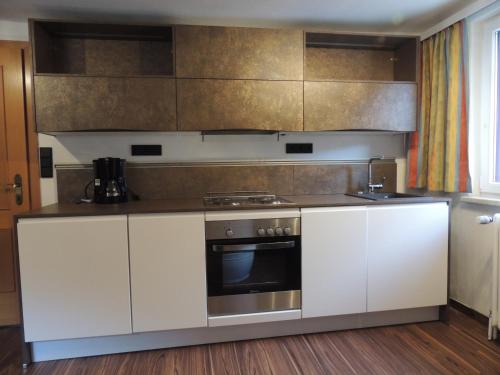a kitchen with white cabinets and a stove at Villa Anna in Bad Gastein