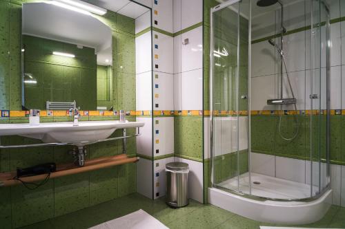 a green bathroom with a sink and a shower at NORDIC Home in Deva