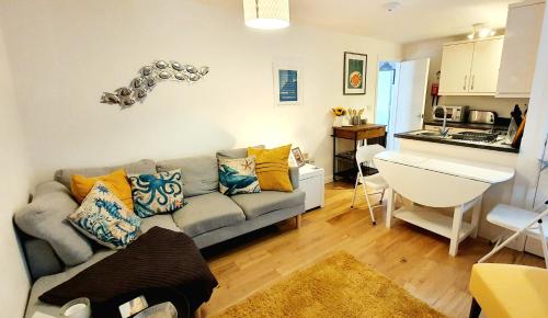ein Wohnzimmer mit einem Sofa und einer Küche in der Unterkunft Stunning apartment with 2 bedrooms, 2 en-suites, private parking in Bournemouth