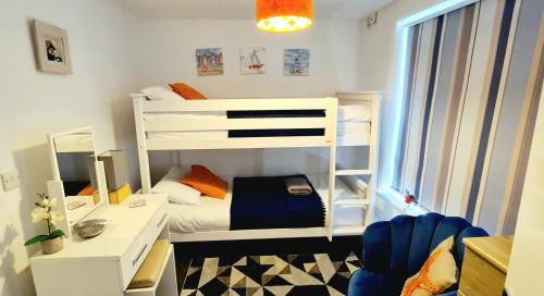 um pequeno quarto com 2 beliches e uma secretária em Stunning apartment with 2 bedrooms, 2 en-suites, private parking em Bournemouth