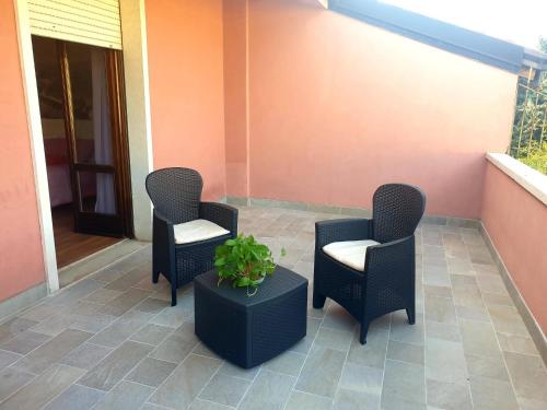 three chairs and a table with a plant on a porch at Casa Dàmoli in Negrar