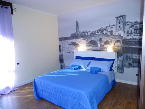 a bedroom with a bed with a painting of a bridge at Casa Dàmoli in Negrar