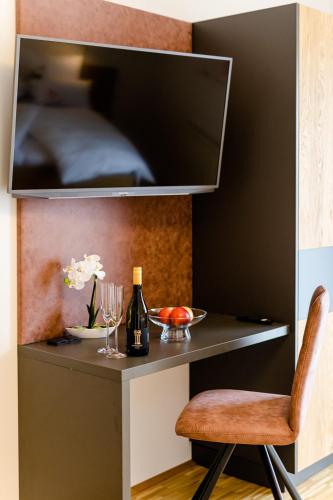 a table with a bottle of wine and a chair at Gästezimmer Das Hambammer in Heimschuh