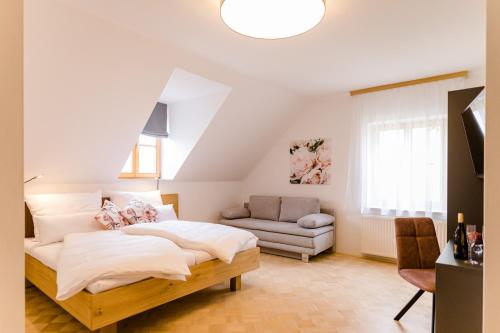 a bedroom with a large bed and a couch at Gästezimmer Das Hambammer in Heimschuh