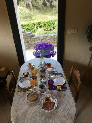 Le BeaucetにあるLa Bergerie Pradelの食べ物の皿が置かれたテーブル