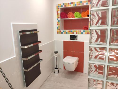 uma casa de banho com um WC e uma parede de azulejos coloridos. em Los Tres Monos em Ávila