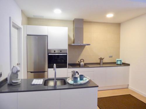 a kitchen with a sink and a stainless steel refrigerator at Norasuites28 in Las Lagunas