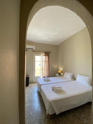 1 dormitorio con 2 camas y ventana en Pansion Roulis, en Mesongi