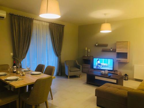 a living room with a dining table and a television at Villa Marietta in Sidari