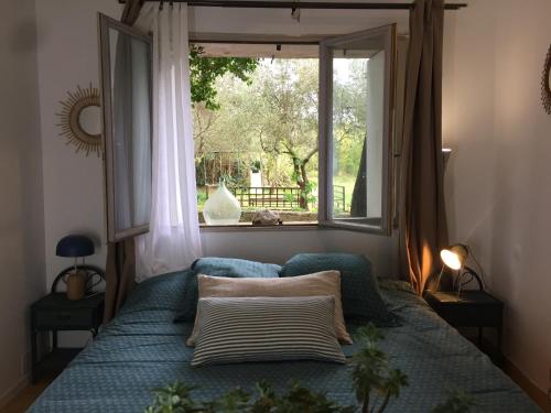 a bedroom with a bed with a window and a windowneauneauneau at Domaine Sesquier Mas d'exception Jasmin in Mèze