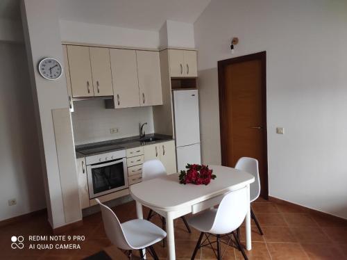 a small kitchen with a white table and chairs at Atico Cuntis Thermae in Cuntis