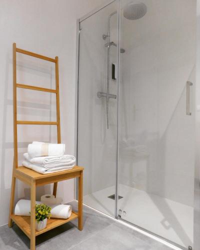a bathroom with a shower and a table with towels at Apartamento La Placeta in Monroyo
