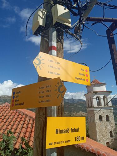 a pole with signs on it next to a tower at Amphora Guesthouse in Himare