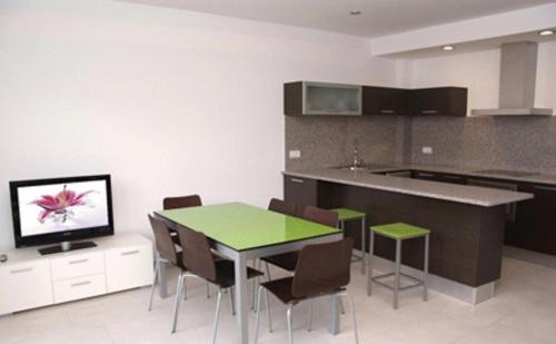 a kitchen with a table and chairs and a television at Apartaments Verd Natura in Olot