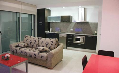 ein Wohnzimmer mit einem Sofa und einer Küche in der Unterkunft Apartaments Verd Natura in Olot