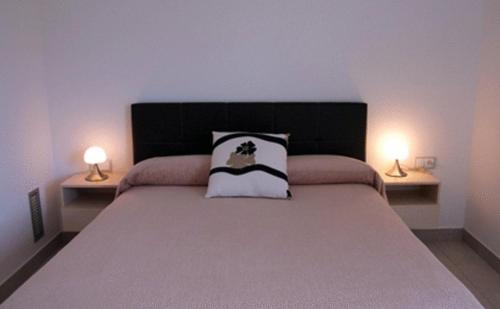 a bedroom with a large bed with two lamps at Apartaments Verd Natura in Olot
