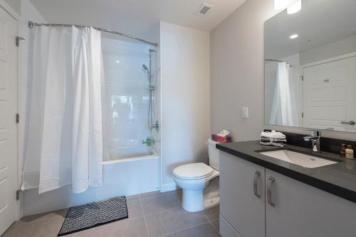 a bathroom with a toilet and a sink and a shower at Lower Lonsdale Aprtment in North Vancouver