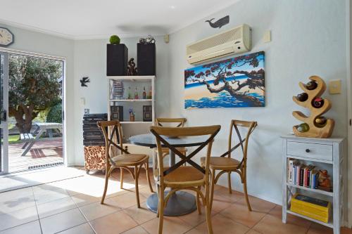 a dining room with a table and chairs at Fantails Roost - Bowentown Holiday Home in Waihi Beach