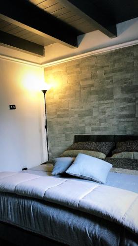 a bed in a room with a brick wall at A casa di Raffaella e Antonio in Surbo