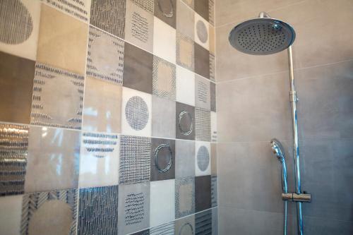 a bathroom with a shower with a tiled wall at Zima Blue in Zygi