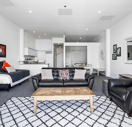 a living room with a couch and a coffee table at Auckland Waterfront Serviced Apartments on Prince's Wharf in Auckland