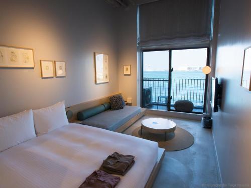 a bedroom with a bed and a view of the ocean at HOTEL ANTEROOM NAHA in Naha