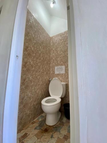 a bathroom with a white toilet in a room at Location One Eighty in Bangcusay