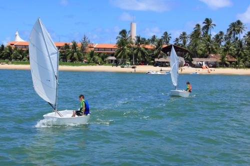 two people on sailboats in the water near a beach at Serrambi Resort in Porto De Galinhas
